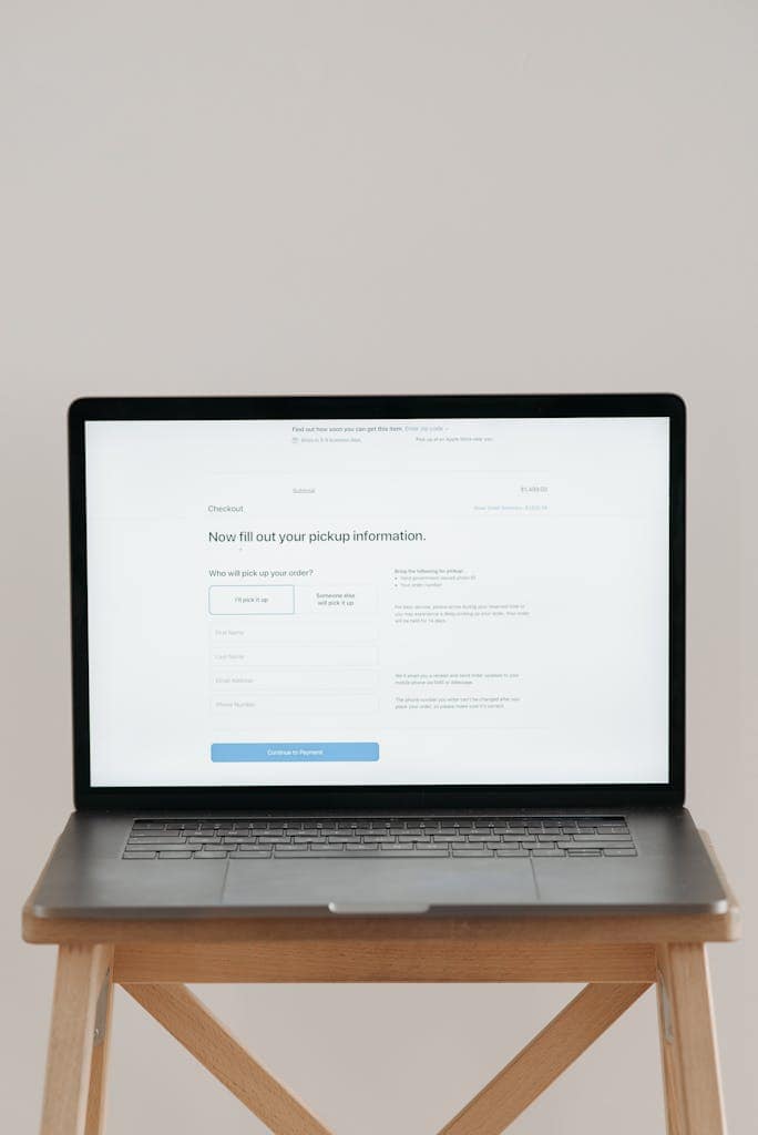 Moderner Laptop mit einem Checkout-Formular vor beigem, minimalistischen Hintergrund – Webdesign mit Extras